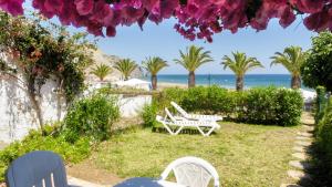 une terrasse avec une table et des chaises et la plage dans l'établissement Casa Sol e Praia, à Luz