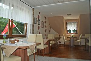 a restaurant with tables and chairs and a window at Pension Belzer in Boppard
