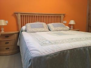 una camera da letto con un grande letto con due cuscini di A Postiña ad Areas