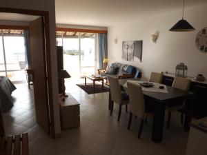 een eetkamer en woonkamer met een tafel en stoelen bij Vila Gaivota Mare Azur in Ferragudo