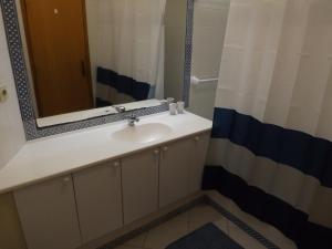 een badkamer met een wastafel en een spiegel bij Vila Gaivota Mare Azur in Ferragudo +30 foto's