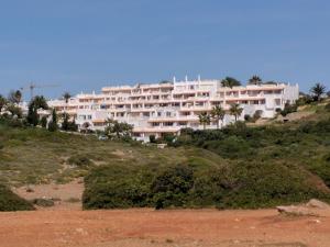 een groot wit gebouw bovenop een heuvel bij Vila Gaivota Mare Azur in Ferragudo
