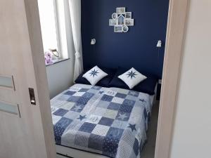 ジブヌベクにあるApartamenty Trioの青いベッドルーム(枕付きのベッド付)