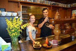 Um homem e uma mulher à frente de um balcão. em Hotel Grüner Baum em Naila