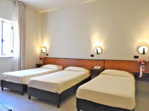 a hospital room with three beds and a window at Hotel Scigliano in Rossano