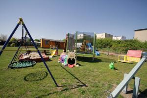 a playground with swings and toys on the grass at Domki-Apartamenty HALS in Władysławowo