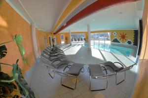 una habitación con una fila de sillas y una piscina en Apparthotel Bliem, en Schladming