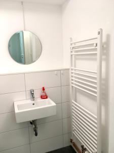 Ruhige Wohnung in zentraler Lage Tübingens في توبينغن: حمام أبيض مع حوض ومرآة