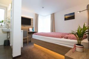 a bedroom with a bed and a desk and a television at Pension Klein in Bad Laasphe