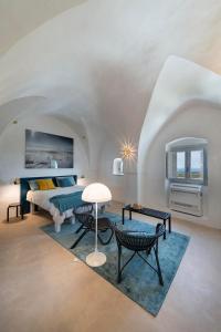 1 dormitorio con 1 cama, mesa y sillas en Torretta Alchimia, en Ostuni