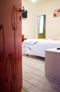 a room with a bed and a kitchen with a door at B&B L'Arcobaleno in Pula