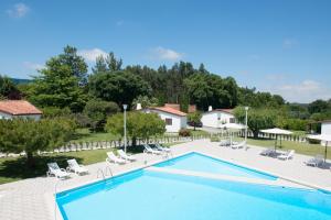 ein großer Swimmingpool mit Stühlen und ein Haus in der Unterkunft Hotel S. Jorge in Batalha