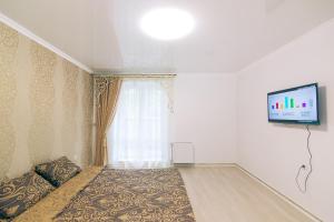 sypialnia z łóżkiem i telewizorem na ścianie w obiekcie VIP apartmen w mieście Sumy
