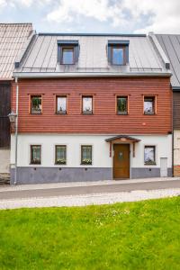 a red and white house with a door at Apartmány Na náměstí in Boží Dar