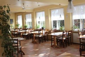 un ristorante con tavoli e sedie in legno e finestre di Pension Walddorf a Winterberg