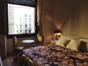 Schlafzimmer mit einem Bett, einem Fenster und einem Tisch in der Unterkunft Lady Luna B&B in Florenz