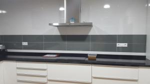 a kitchen with white cabinets and a counter top at Casa Rural CasaBlasa in Santo Domingo de Moya +24 photos