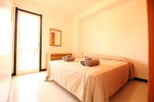 マリーナ・ディ・ラグーザにあるCasa Vacanze Paguroのベッドルーム1室(ベッド1台、タオル2枚付)