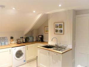 a kitchen with a sink and a washing machine at Chalice Loft in Glastonbury