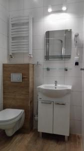 a white bathroom with a toilet and a sink at Domus in Ustka +45 photos