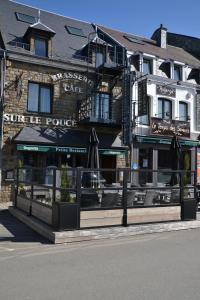 um restaurante com guarda-sóis em frente a um edifício em Auberge Le Temps des Saveurs em Paliseul