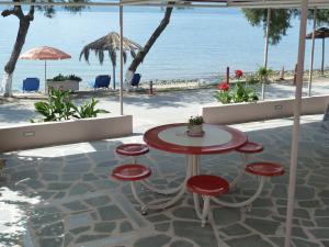 a table and stools with a view of the beach at The Twins in Glida