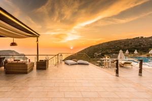 a balcony with a sunset on a cruise ship at Petani Bay Hotel - Adults Only in Vóvikes