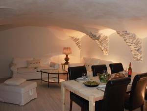 a living room with a table and chairs and a couch at Très bel appartement, Parc national des Écrins, piscine et terrasse in Les Vigneaux