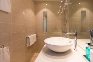 La salle de bains est pourvue d'un grand lavabo blanc sur un comptoir. dans l'établissement 2 Døtre Apartments, à Bergen