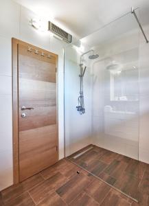 a bathroom with a wooden door and a shower at B&B Apartments Burić Plitvice Lakes in Seliste Dreznicko