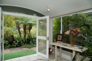 a room with a window and a table with flowers at Serendipity Country House & Restaurant in Wilderness