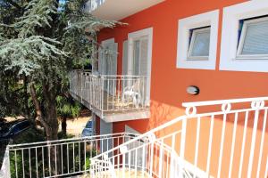 ein orangefarbenes Gebäude mit einem Hund auf dem Balkon in der Unterkunft Bed and Breakfast La Rossa in Umag