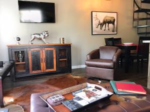 una sala de estar con un perro en la parte superior de una TV en Breck Creekside at Wildwood Suites, en Breckenridge