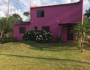 una casa rosa con flores delante en La Rosada, en La Paloma