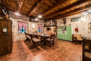 uma cozinha com uma mesa e um frigorífico verde em villa sisman em Donji Zemunik