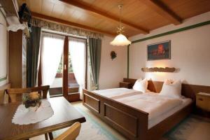 a bedroom with a large bed and a table at Haus Dittrich in Kirchberg in Tirol