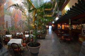 um restaurante com mesas e cadeiras e vasos de plantas em Royal Inka II em Cusco