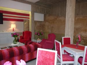 a living room with a red couch and red chairs at Los Calaos de Briones in Briones