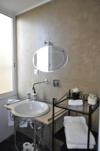 ein Bad mit einem Waschbecken und einem Wandspiegel in der Unterkunft Cativos - Alfama Center District in Lissabon