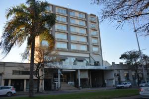 un edificio con una palmera delante de él en Hotel Cuatro Plazas en Casilda