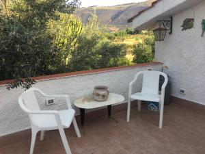 2 sedie e un tavolo e 2 sedie su un patio di Villino Fraginesi a Castellammare del Golfo