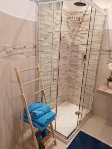 łazienka z prysznicem i niebieskimi ręcznikami. w obiekcie Martin Holiday Apartments w mieście Giardini Naxos