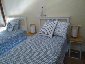 アヤモンテにあるApartamento Costa Esuri Golfのベッドルーム1室(ベッド2台、青と白の枕付)