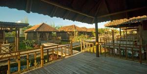 a resort with a wooden deck and some buildings at Gardenia Resort and Spa in Pontianak