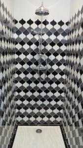 une salle de bain avec un mur à carreaux noir et blanc dans l'établissement Mas Bonement, à Arles