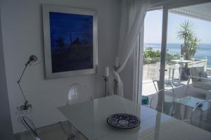 a white dining room with a view of the ocean at Beach-Front Bahia Dorada in Estepona