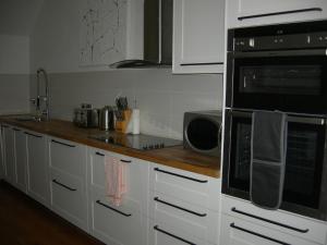 a kitchen with white cabinets and black appliances at High Street Suites 3 in Ventnor