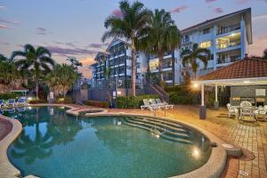 a swimming pool in front of a building at North Cove Waterfront Suites in Cairns