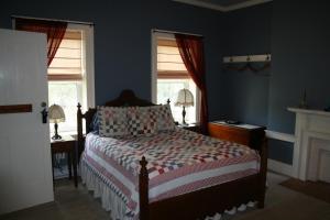 een slaapkamer met een bed en 2 ramen bij The 1819 Red Brick Inn in Dundee