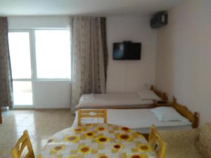 a bedroom with a bed and a table and chairs at Guest House D. Bogdanova in Obzor